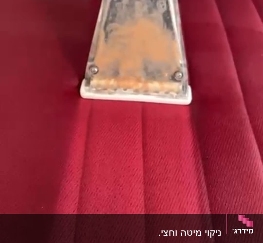 ניקוי ספה עם מכשיר שאיבה על בד אדום